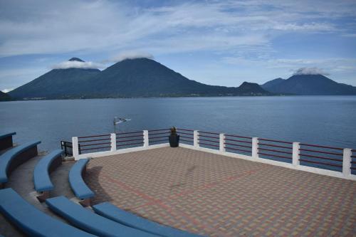 a person standing on the edge of a pier near the water at Casa Gaspar on Lake Atitlán in San Antonio Palopó