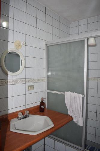 a bathroom with a sink and a shower with a mirror at Casa Gaspar on Lake Atitlán in San Antonio Palopó