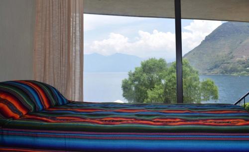 a couch in a room with a large window at Casa Gaspar on Lake Atitlán in San Antonio Palopó