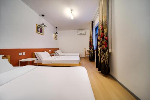 a hotel room with two beds and a couch at Xi'an Travelling with Hotel South Gate in Xi'an