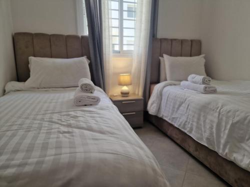 Dos camas una al lado de la otra en un dormitorio. en Modern Flat Between Forest, Beach & Airport, en Tánger