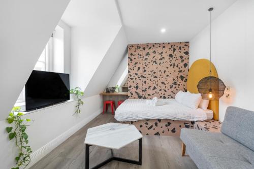 a living room with a couch and a tv at Brick Lane Base in London