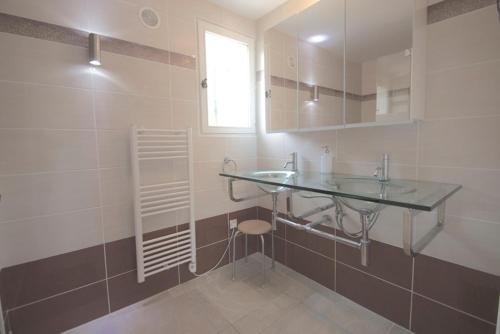 La salle de bains est pourvue d'un comptoir en verre et d'un lavabo. dans l'établissement Villa Roca, aux Issambres