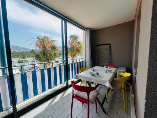 une table et des chaises dans une pièce avec une grande fenêtre dans l'établissement Argelès sur Mer - Appartement 6 pers avec terrasse et parking - FR-1-309-375, à Argelès-sur-Mer