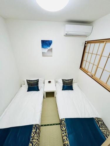 two beds in a room with a window at Arashi - Ikebukuro 10 min Shinjuku 20 min in Tokyo
