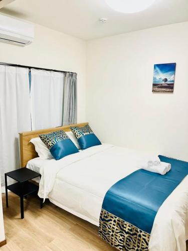 a bedroom with two beds with blue pillows at Arashi - Ikebukuro 10 min Shinjuku 20 min in Tokyo