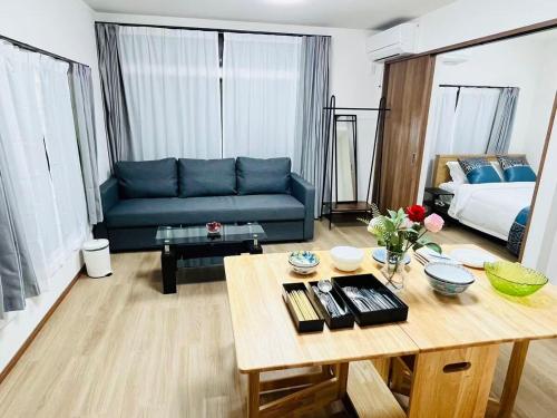 a living room with a blue couch and a table at Arashi - Ikebukuro 10 min Shinjuku 20 min in Tokyo