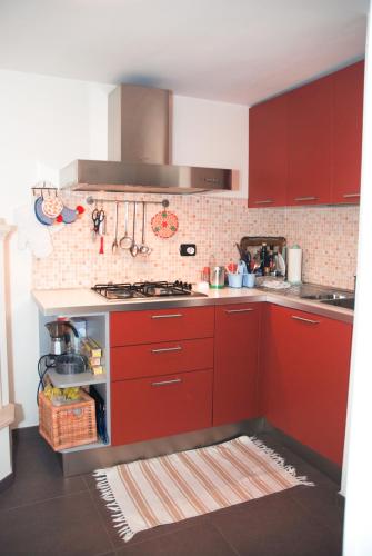 a kitchen with red cabinets and a stove at Casa Meravigli in Cutrofiano