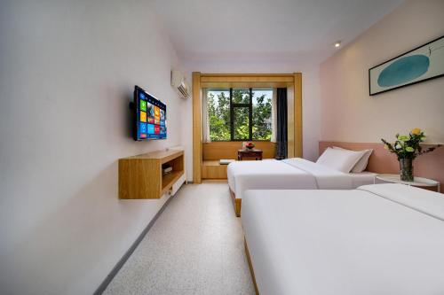 a hotel room with two beds and a television at Xi'an Travelling with Hotel South Gate in Xi'an