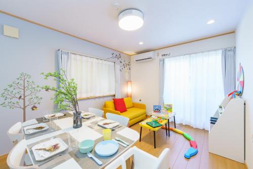 a living room with a table and a yellow couch at DREAM STAY Urayasu in Tokyo
