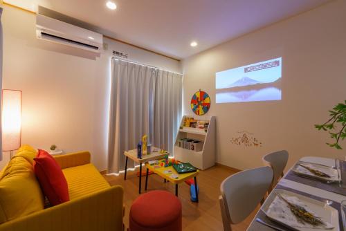 a living room with a yellow couch and a table at DREAM STAY Urayasu in Tokyo