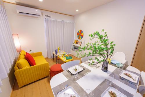 a living room with a dining table and a yellow couch at DREAM STAY Urayasu in Tokyo