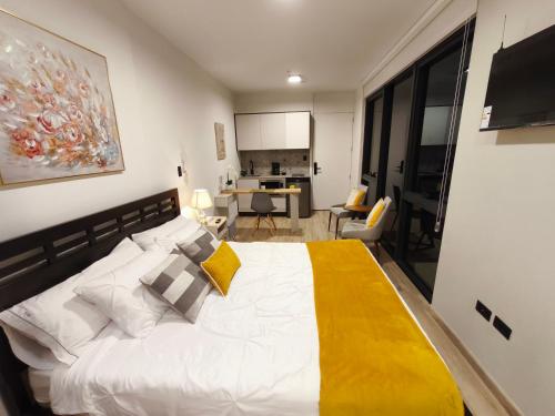 a bedroom with a large white bed with a yellow blanket at Republica del Salvador Coliving Ecuador XOE in Quito