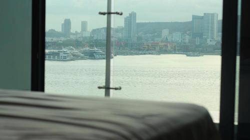 a window with a view of the water and a city at An Bình homestay - Sapphire S2, Bến Đoan, Hạ Long, Quảng Ninh in Ha Long