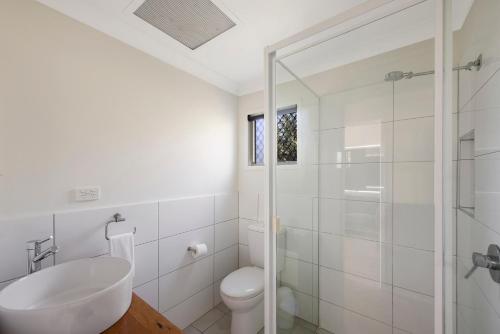 a bathroom with a toilet and a sink and a shower at Reflections Seal Rocks - Holiday Park in Smiths Lake