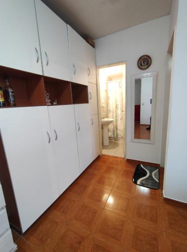 a kitchen with white cabinets and a wooden floor at Vista sur in Buenos Aires