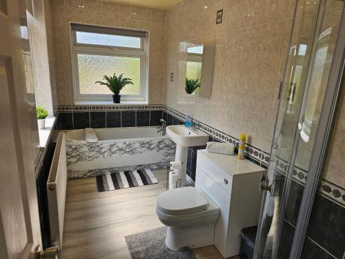 a bathroom with a toilet and a tub and a sink at Fantastic 4 Apartments in Dagenham Dock