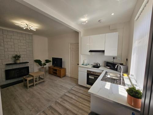 a kitchen with white cabinets and a counter top at Fantastic 4 Apartments in Dagenham Dock