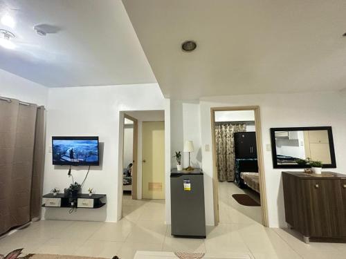 a living room with a tv on the wall at 2-BR CONDO Staycation Sea Residence -Kharen in Manila