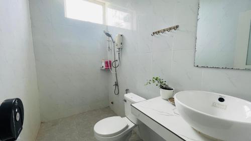 a white bathroom with a sink and a toilet at TATEK Villa in Kampot