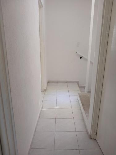 Un pasillo vacío con suelo de baldosas y una puerta abierta. en Kasa koko, en Cancún