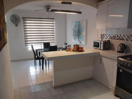Una cocina con encimera y mesa con sillas. en Kasa koko, en Cancún