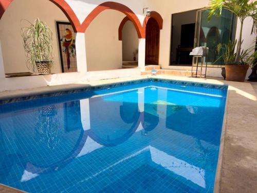 a swimming pool with blue tile in a house at Suites paty de Suites Rocio in Isla Mujeres