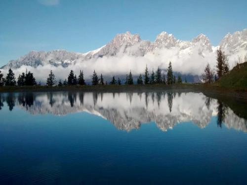 a reflection of a mountain in a lake with clouds at Chalet in Ellmau near Ski Slopes in Ellmau