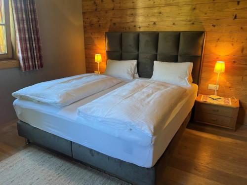 a large bed in a bedroom with two lamps on tables at Chalet in Ellmau near Ski Slopes in Ellmau