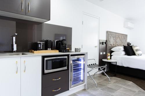 a kitchen with a microwave on a counter with a bed at Fountain View Motel in Dubbo