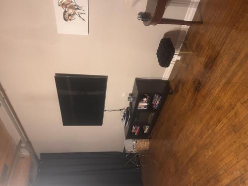 a room with a television on the wall and stairs at Queen G Investments apts in Detroit
