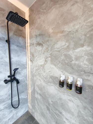 a bathroom with a shower with four bottles of essential oils at Republica del Salvador Coliving Ecuador XOE in Quito
