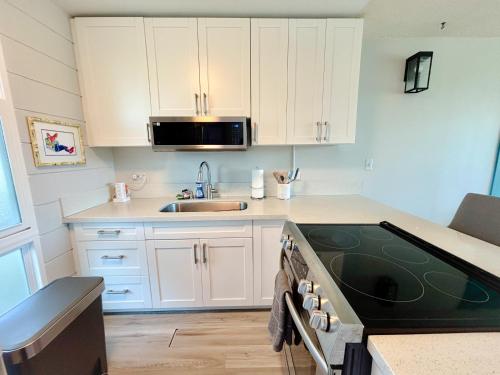 a kitchen with white cabinets and a sink at Chic Salt Lake 2-Bedroom FG condo in Honolulu