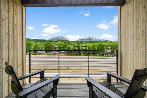 two chairs on a deck with a view of mountains at 4-Season Modern Mountain Penthouse with Private Hot Tub & Scenic Views in Silverthorne
