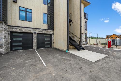 a parking lot in front of a building with two garage doors at 4-Season Modern Mountain Penthouse with Private Hot Tub & Scenic Views in Silverthorne
