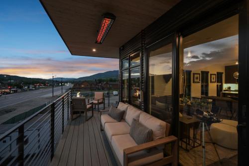 a balcony with a couch and a view of a street at 4-Season Modern Mountain Penthouse with Private Hot Tub & Scenic Views in Silverthorne