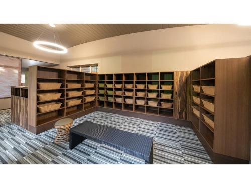 a library with wooden shelves and a stool in a room at Harazuru Onsen Taisenkaku - Vacation STAY 96472v in Asakura