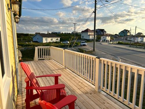 two red chairs sitting on the porch of a house at Meg Inn Peggys Cove in Peggy's Cove