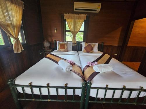 a bedroom with a large bed with white sheets at Insda Wellness Resort in Chiang Mai