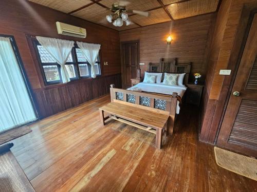 a bedroom with a bed and a wooden floor at Insda Wellness Resort in Chiang Mai