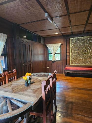 a dining room with a wooden table with flowers on it at Insda Wellness Resort in Chiang Mai