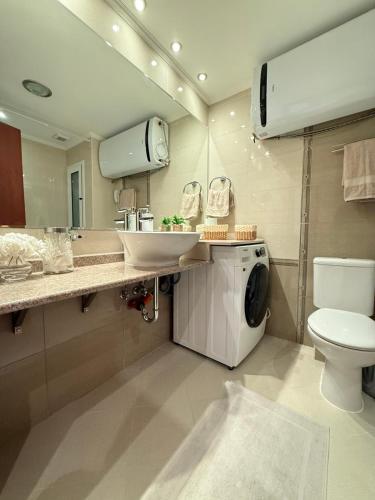 a bathroom with a sink and a washing machine at Downtown Bansko Luxury Resort in Bansko