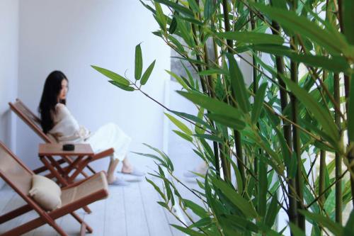 a woman sitting in a chair in a room at Wuxing Qinglan Homestay in Houhong