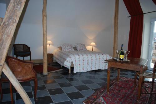 ein Schlafzimmer mit einem Bett und einem Tisch mit einer Flasche Wein in der Unterkunft lisa's weelde in Tongeren