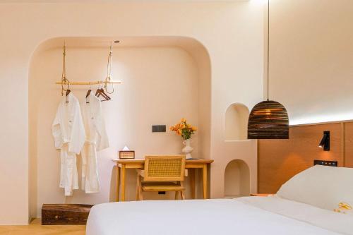 a bedroom with a bed and a desk and a chair at Wuxing Qinglan Homestay in Houhong