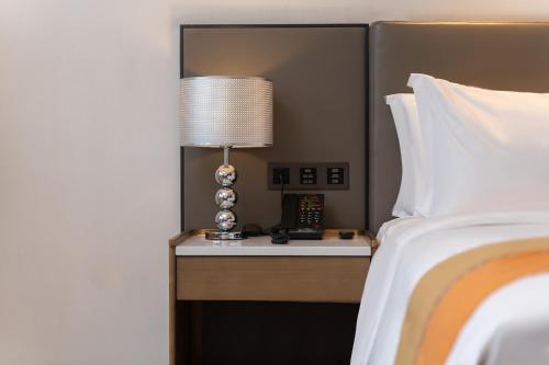 a bedroom with a bed and a table with a lamp at Changsha Feiji Hotel in Changsha