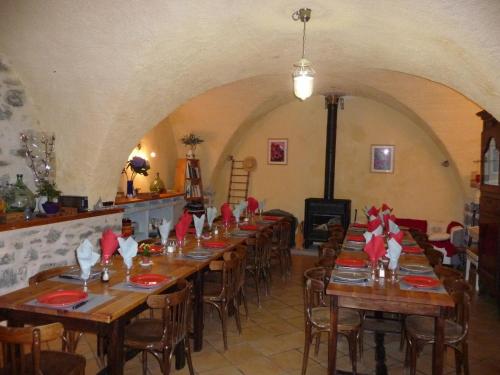 une salle à manger avec de longues tables et des serviettes rouges dans l'établissement Gîte d'Etape Auberge de l'Ardoisière, à Jausiers