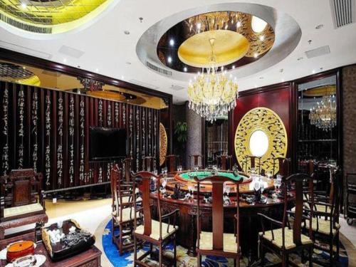 a dining room with a table and chairs and a chandelier at Fuzhou Xin Zi Yang Hotel in Fuzhou