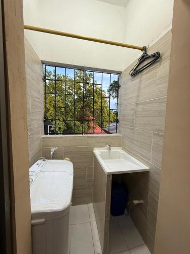 a bathroom with a sink and a toilet and a window at Apartamento CRISALF in Santa Cruz de Mompox