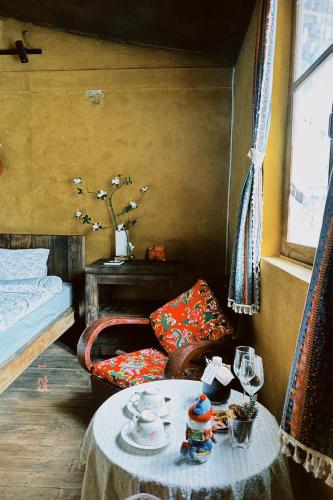 a room with a table and a chair and a bed at Maison de Hill Home in Dồng Văn